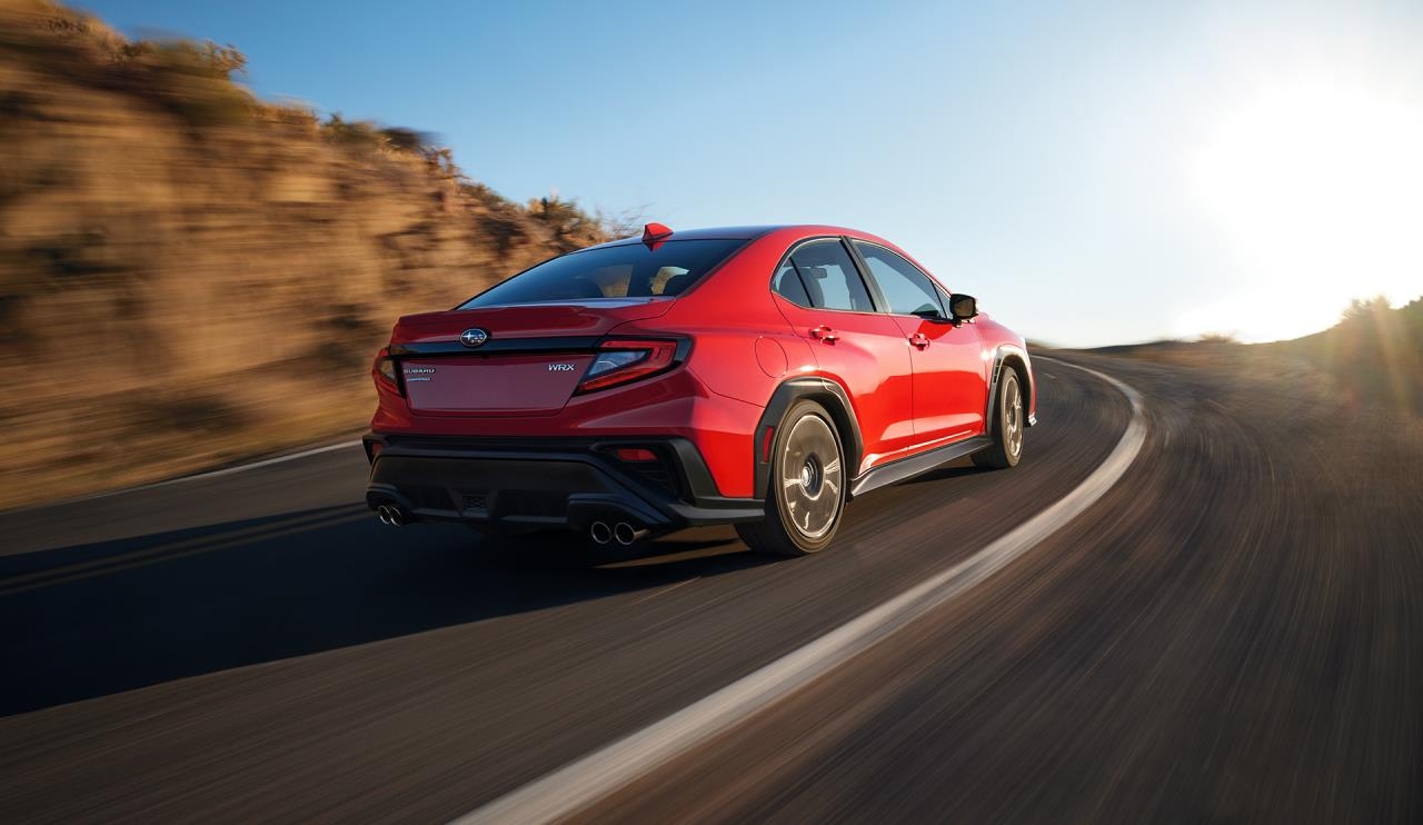 Vue 3/4 arrière du Subaru WRX 2024 rouge sur la route. 