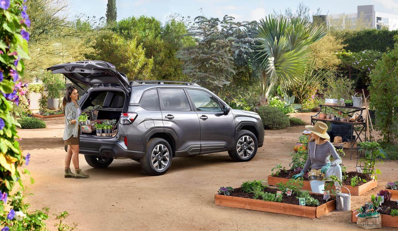 Compartiment de charge ultra polyvalent du Subaru Forester 2025 garé dans un jardin.